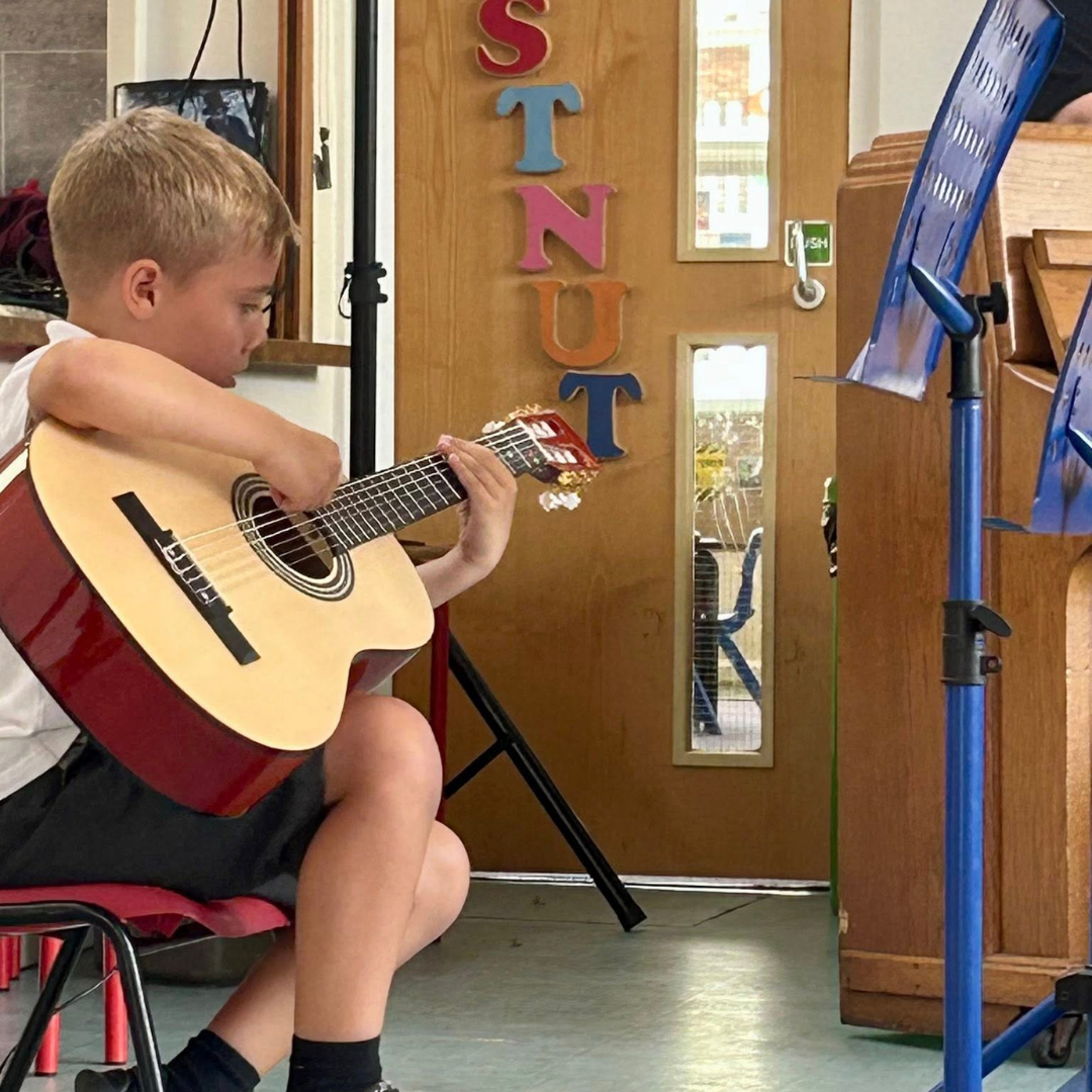 a pupil playing guitar