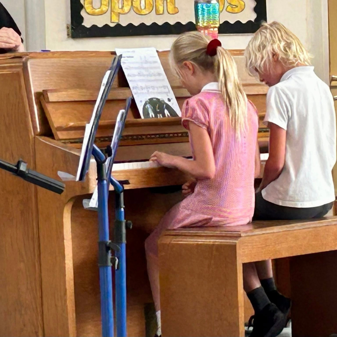 two pupils playing piano